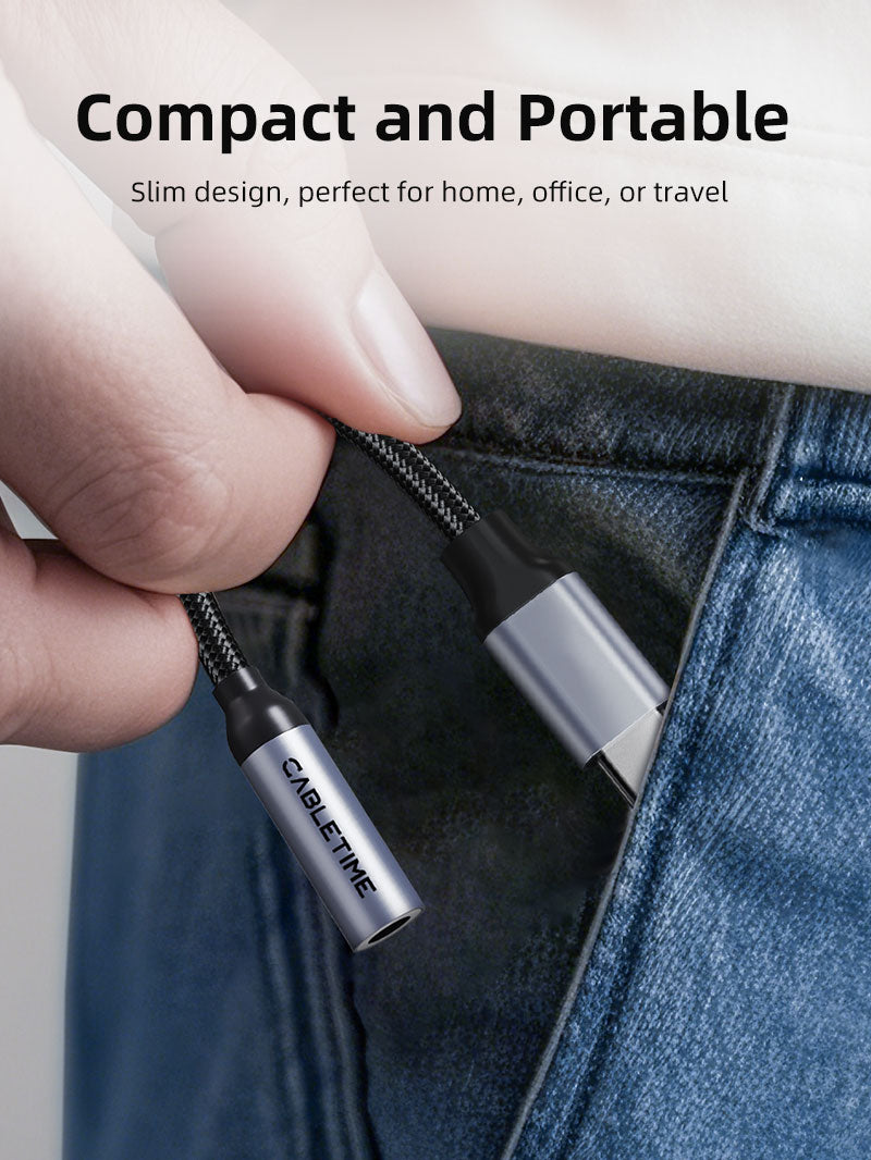 Hand placing the compact Cabletime USB-C to 3.5mm audio adapter into a jeans pocket, highlighting its portable and travel-friendly design.