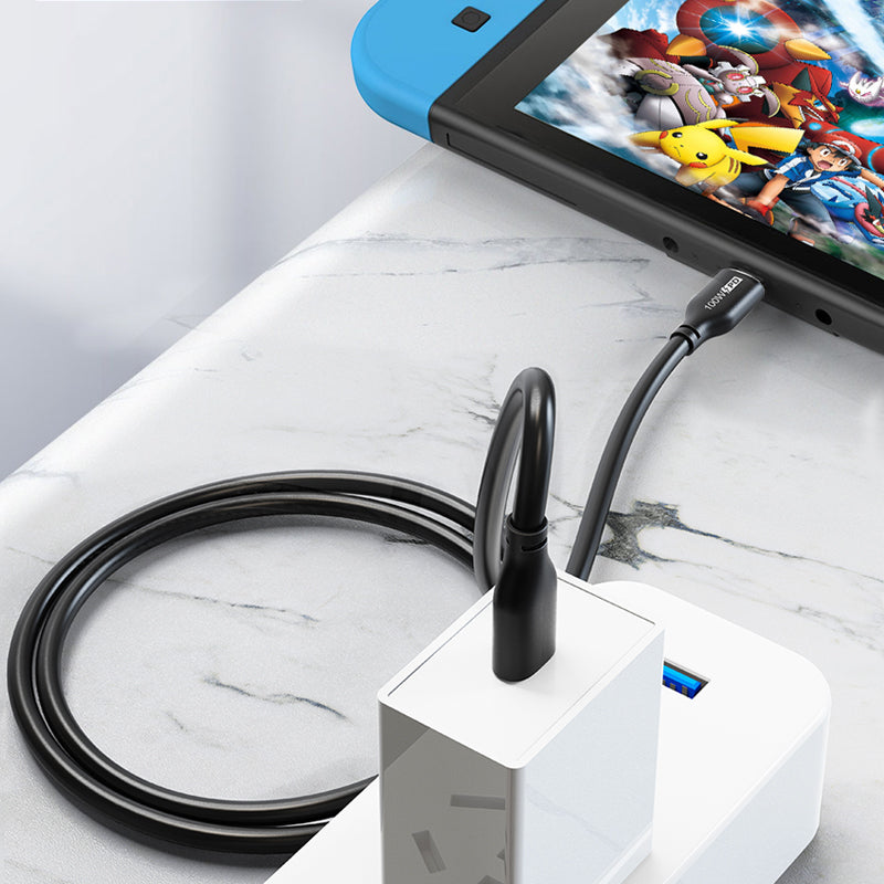 Black USB-C cable connected to a Nintendo Switch console and a wall charger, shown as a charging setup.